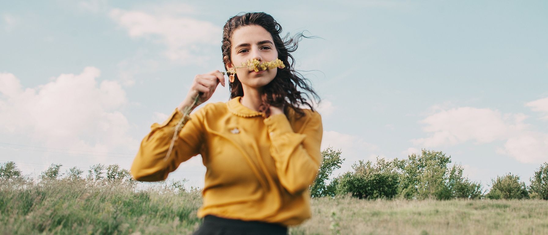 Mujer joven oliendo una flor